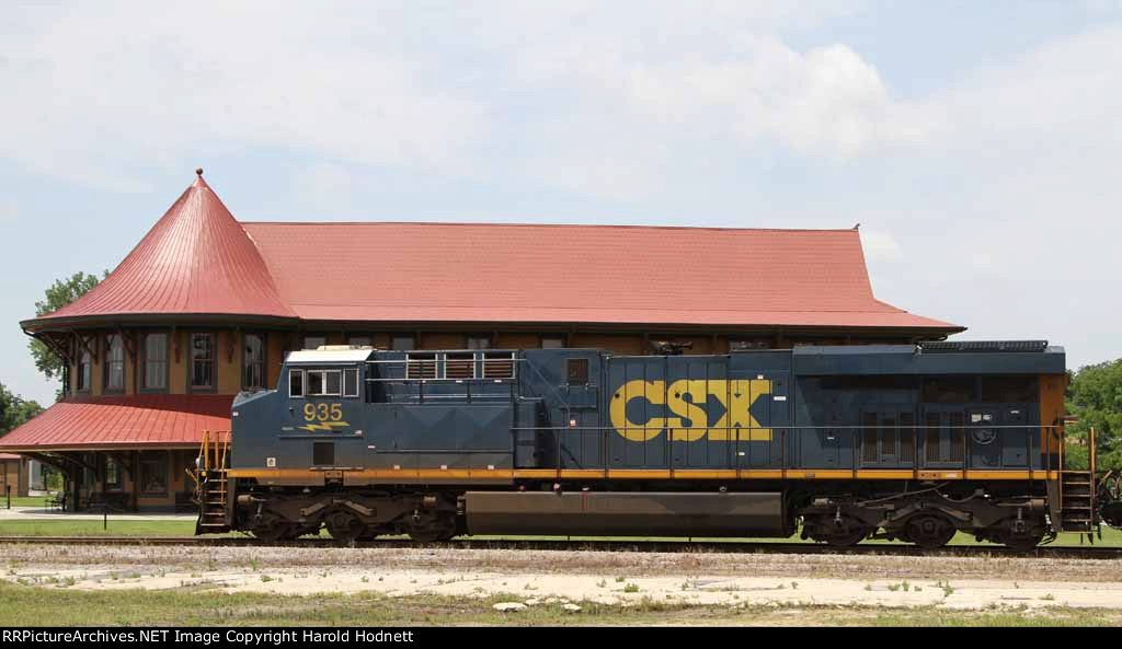 CSX 935 leads a train past the station